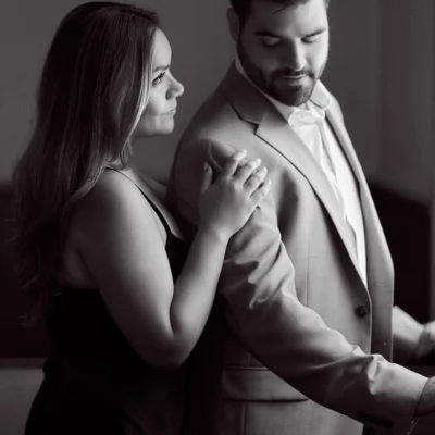 Girl holding man next to a window Black Creek Village Engagement Photoshoot