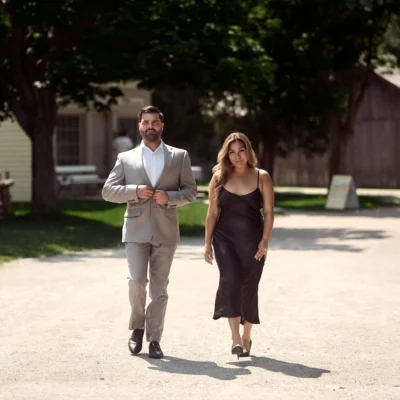 Man and woman walking in the middle of dirt road Black Creek Village Engagement Photoshoot