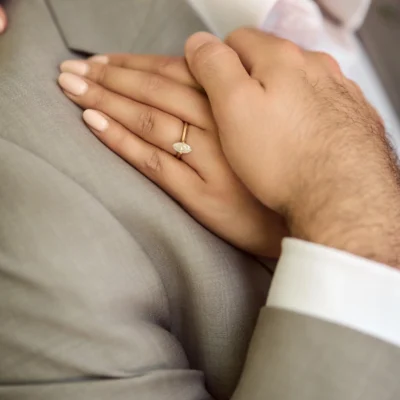Man holding womans hand with engagement ring Black Creek Village Engagement Photoshoot