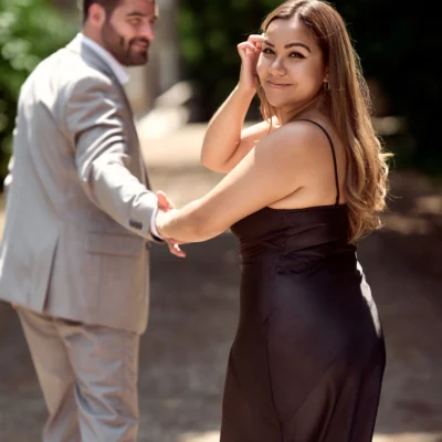 woman looking back while man holds her hand Black Creek Village Engagement Photoshoot