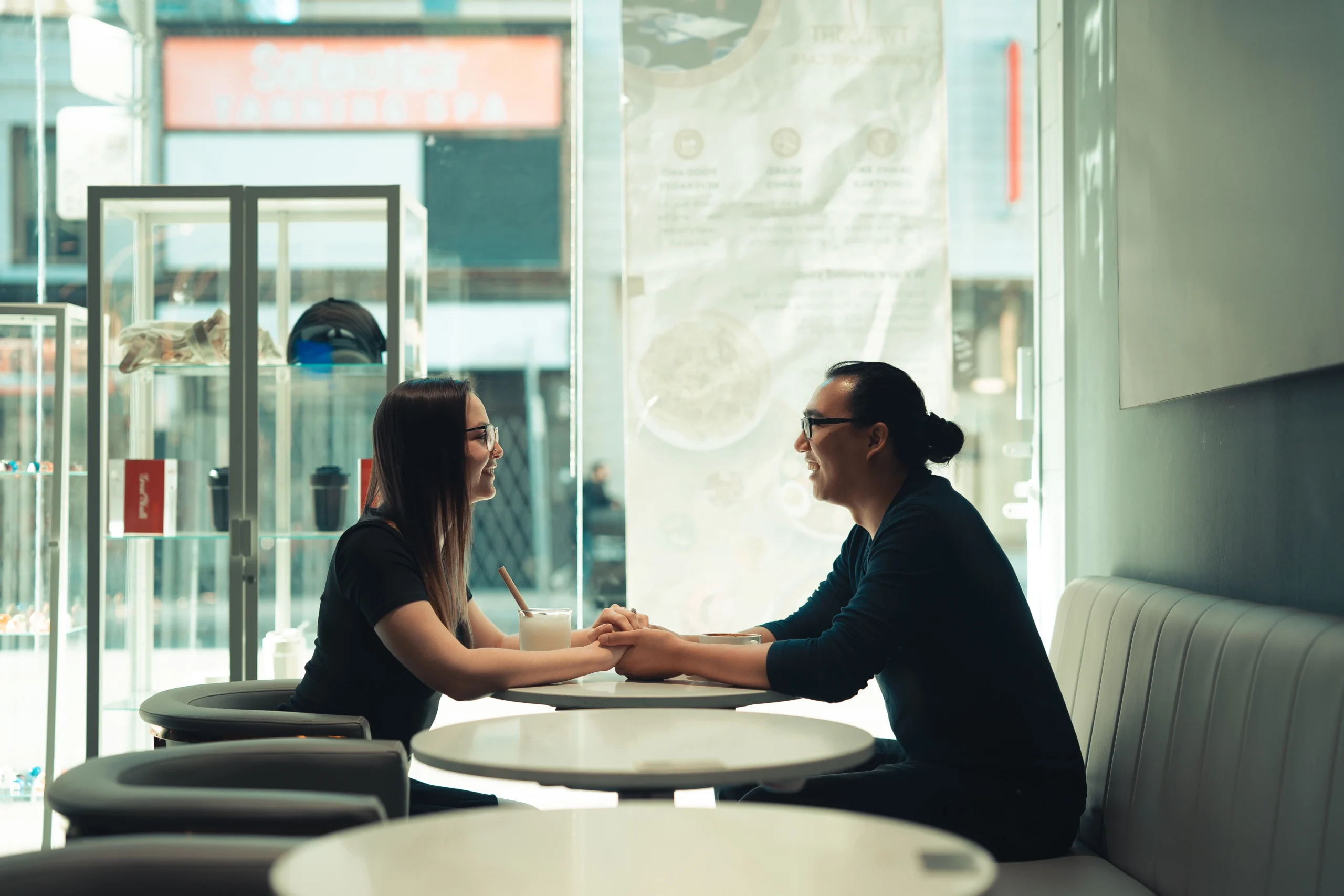 Toronto Couple sitting in restaurant holding hands
