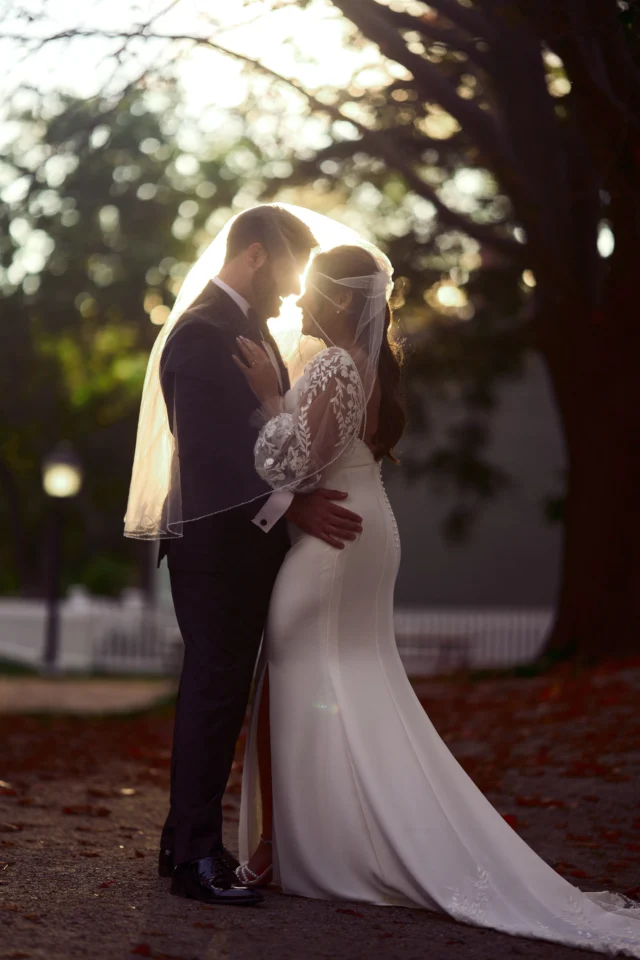Golden hour portrait of bride and groom holding each other outdoors