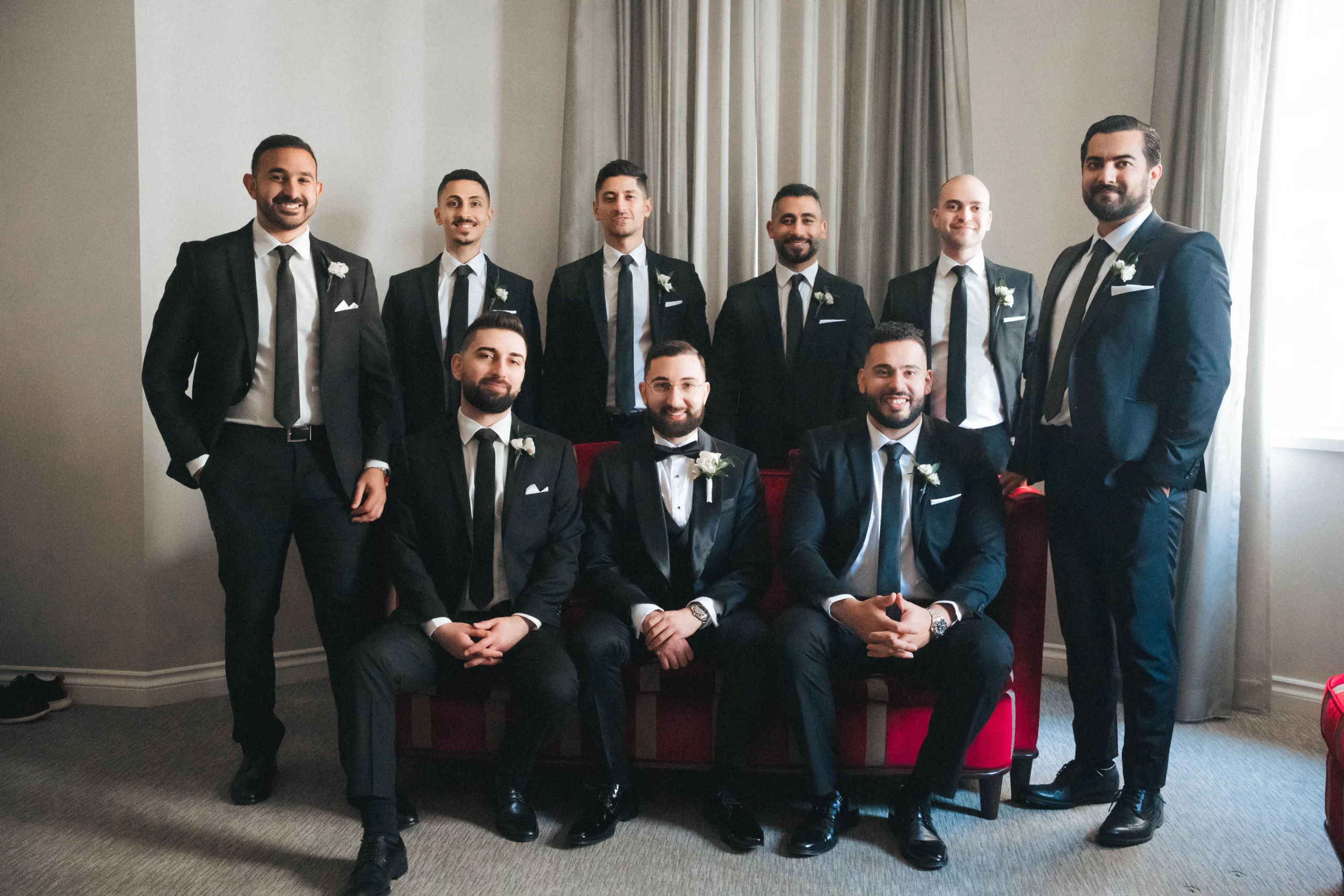 Groom and group posing together in a room