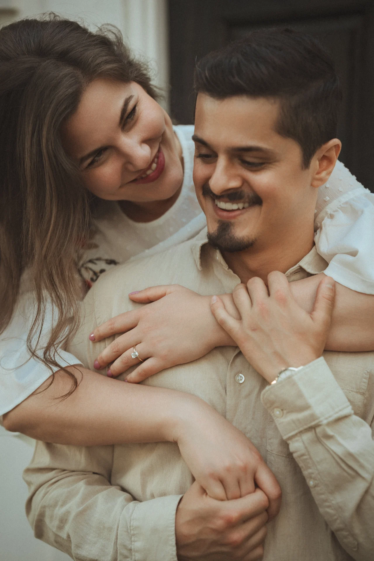 Couple in white and beige outfits holding each other