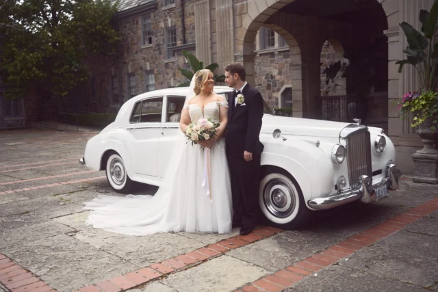 Wedding day outdoor moment with bride and groom near the car