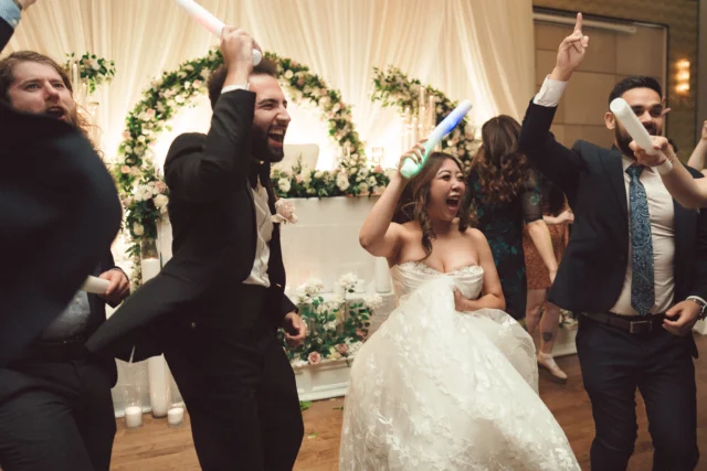 Bride and Groom holding Glowing Sticks and dancing after wedding reception