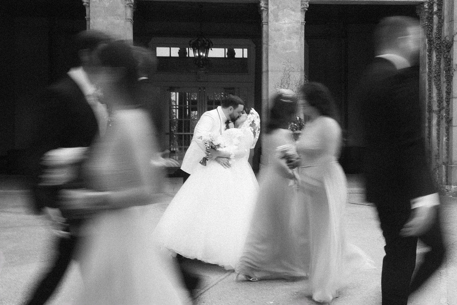 Wedding couple kissing blur wedding party