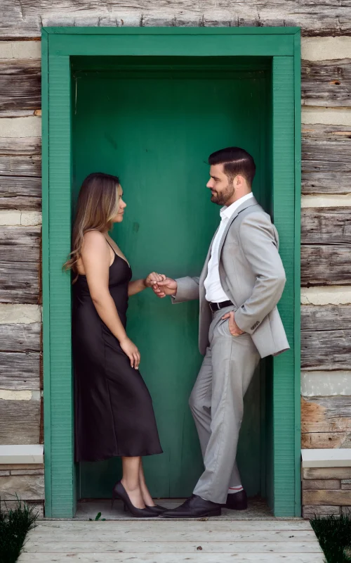 Man and woman next to a green door Black Creek Village Engagement Photoshoot