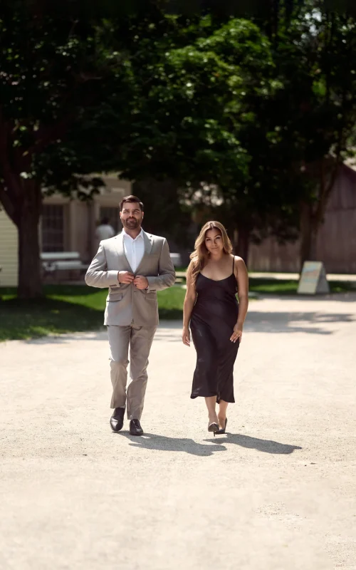 Man and woman walking in the middle of dirt road Black Creek Village Engagement Photoshoot