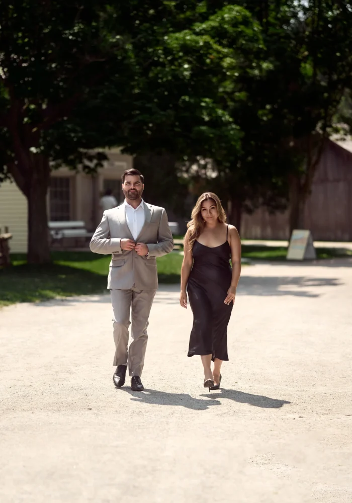 Man and woman walking in the middle of dirt road Black Creek Village Engagement Photoshoot